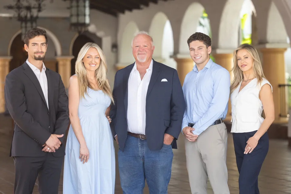 The five members of the Golis Team standing together under a tiled, arched arcade